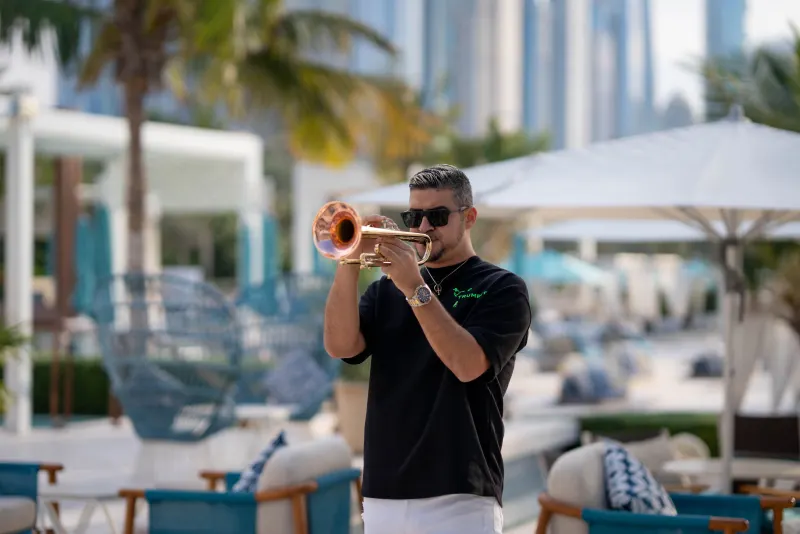 Sergio raising his trumpet, caught in warm side light